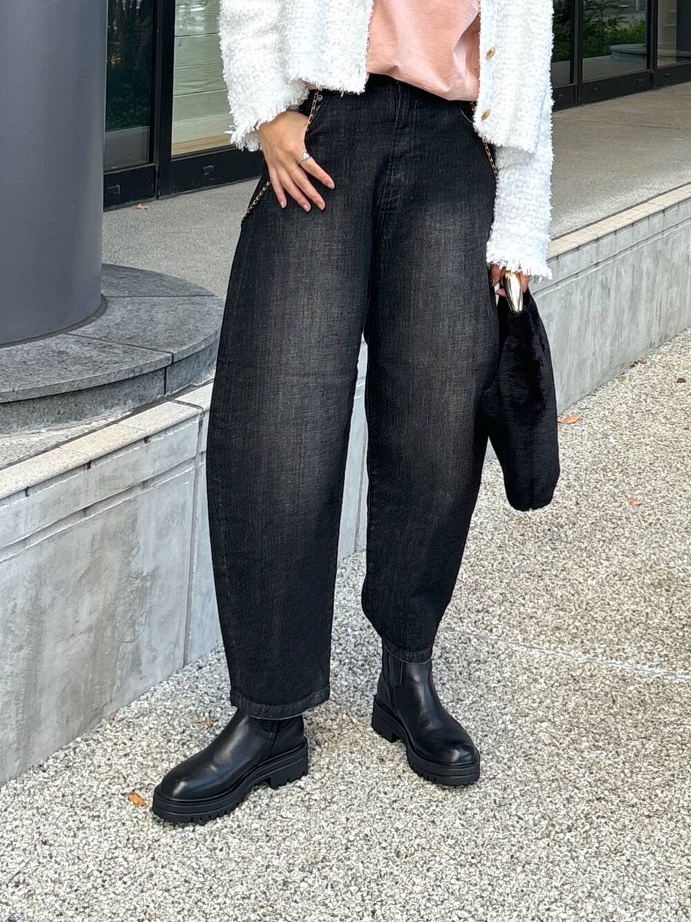 ブラック系のデニムパンツ、ブラック系のブーツ、ブラック系のトートバッグを着用したレディースの秋コーディネートの7枚目の写真