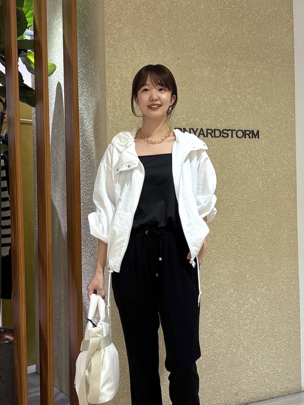 ホワイト系のブルゾン、ホワイト系のトートバッグ、ブラック系のその他パンツを着用したレディースの春コーディネートの2枚目の写真