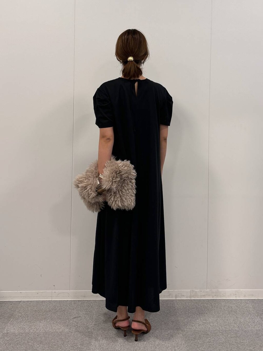 ブラウン系のトートバッグ、ブラック系のワンピース、ブラウン系のパンプスを着用したレディースの秋コーディネートの4枚目の写真