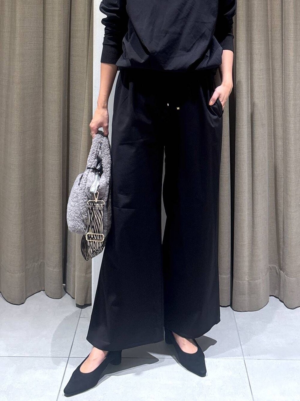 ブラック系のパンプス、グレー系のトートバッグ、ブラック系のTシャツ/カットソーを着用したレディースの秋コーディネートの5枚目の写真