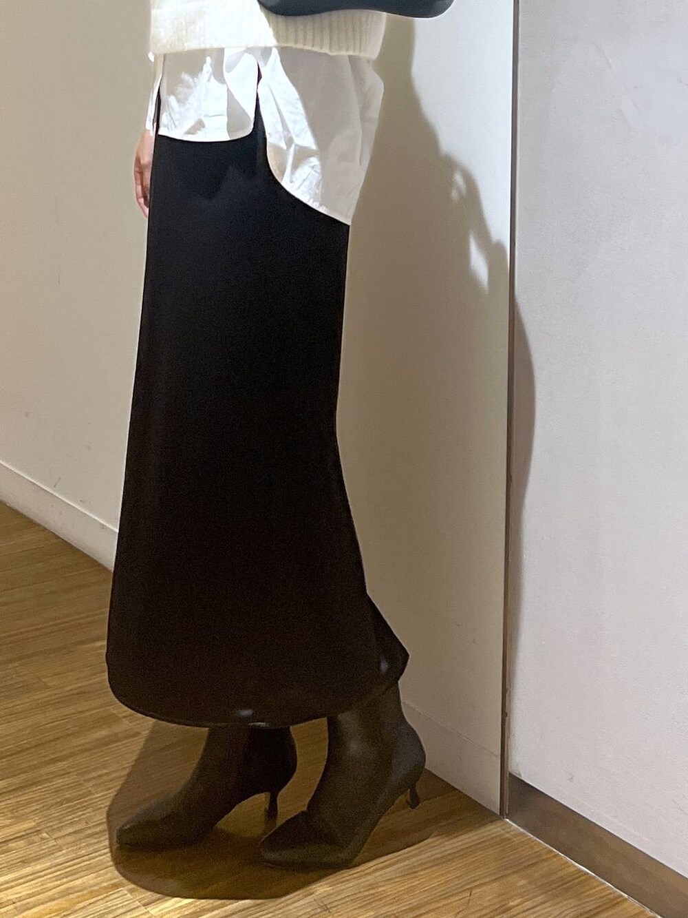 ブラック系のブーツ、ブラック系のショルダーバッグ、ホワイト系のシャツ/ブラウスを着用したレディースの秋コーディネートの4枚目の写真