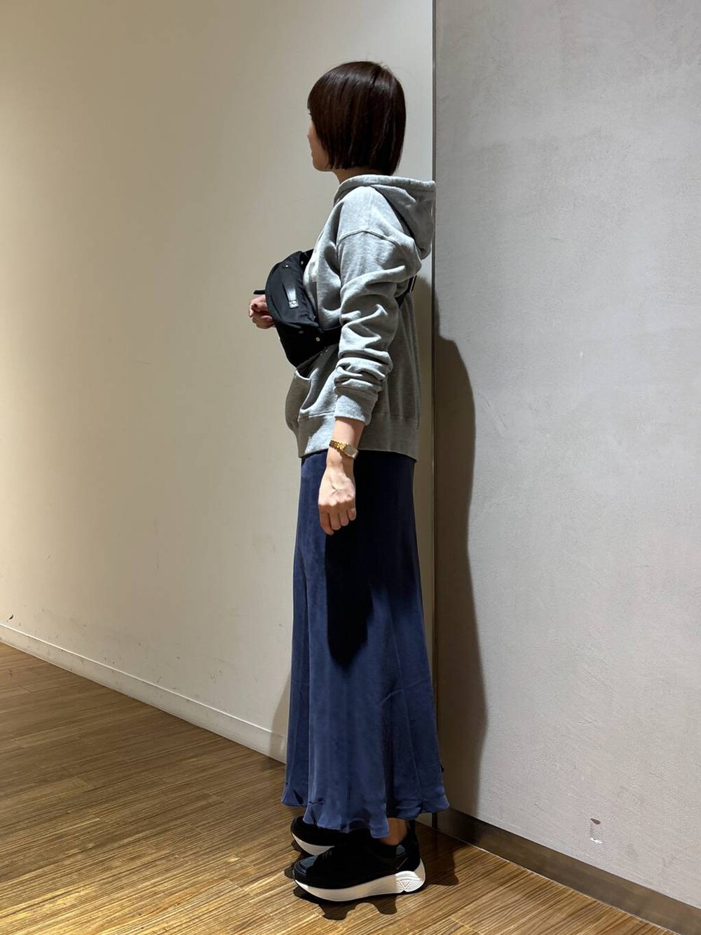 ブラック系のボディバッグ/ウエストポーチ、グレー系のパーカー、ブラック系のスニーカーを着用したレディースの冬コーディネートの2枚目の写真