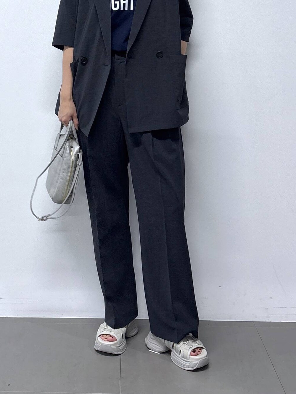 シルバー系のショルダーバッグ、グレー系のサンダル、ブルー系のTシャツ/カットソーを着用したレディースの春コーディネートの5枚目の写真