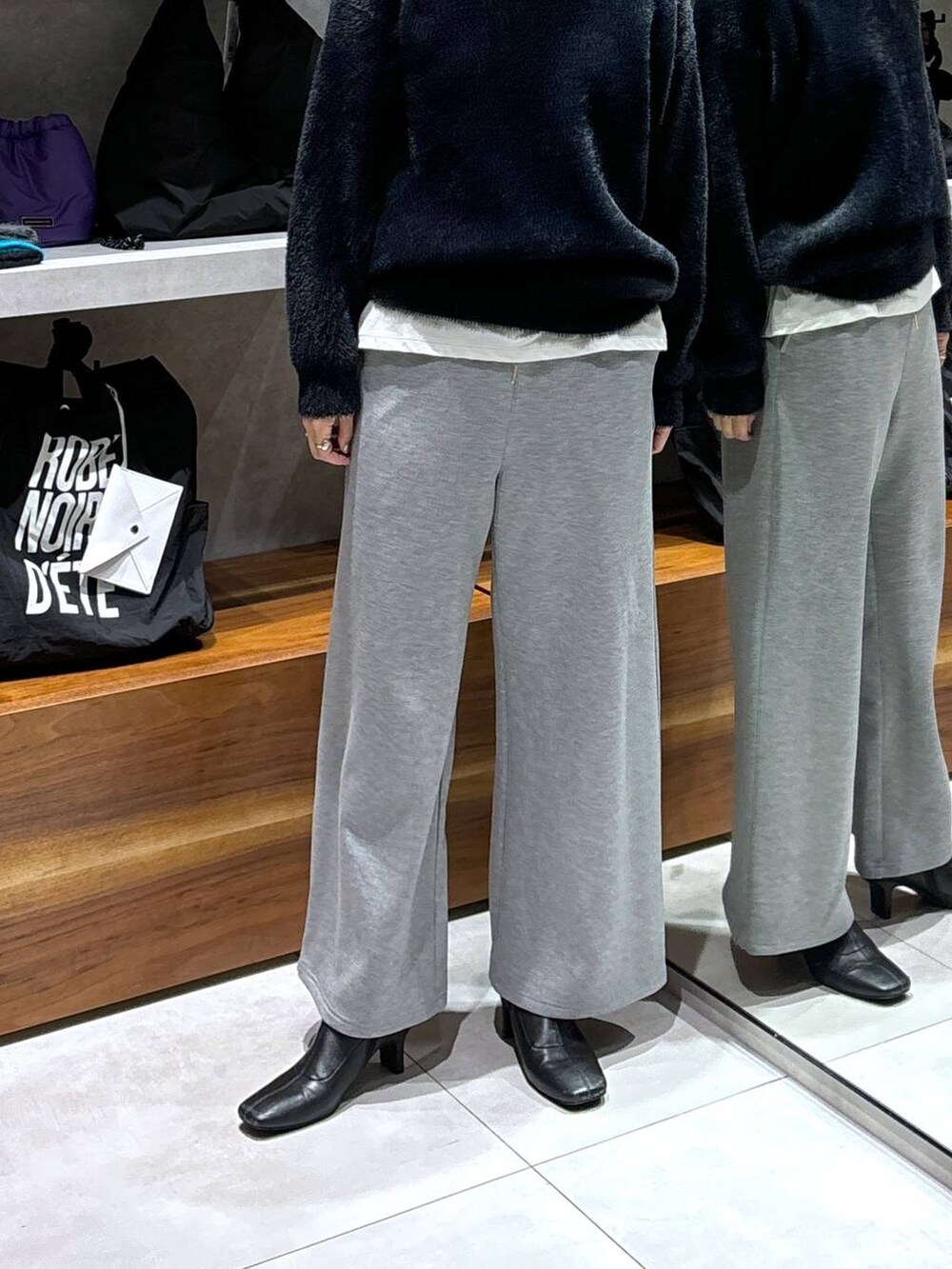 ブラック系のトートバッグ、ホワイト系のTシャツ/カットソー、ブラック系のニット/セーターを着用したレディースの冬コーディネートの3枚目の写真