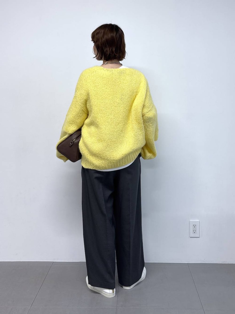 ホワイト系のTシャツ/カットソー、ブラウン系のボストンバッグ、イエロー系のカーディガン/ボレロを着用したレディースの秋コーディネートの3枚目の写真