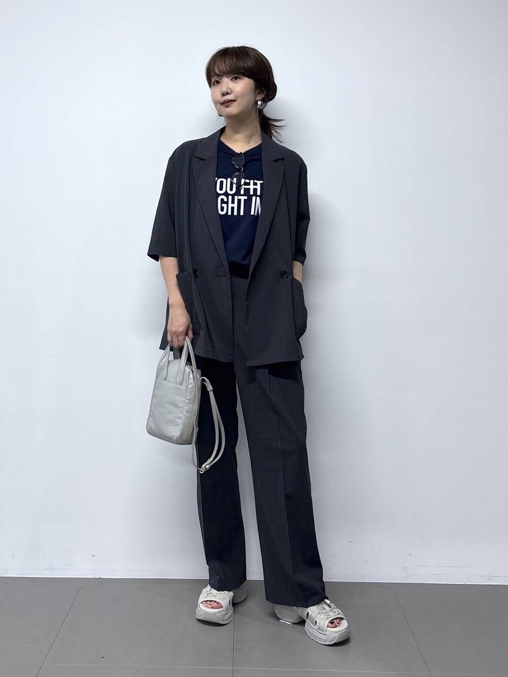 シルバー系のショルダーバッグ、グレー系のサンダル、ブルー系のTシャツ/カットソーを着用したレディースの春コーディネートの6枚目の写真