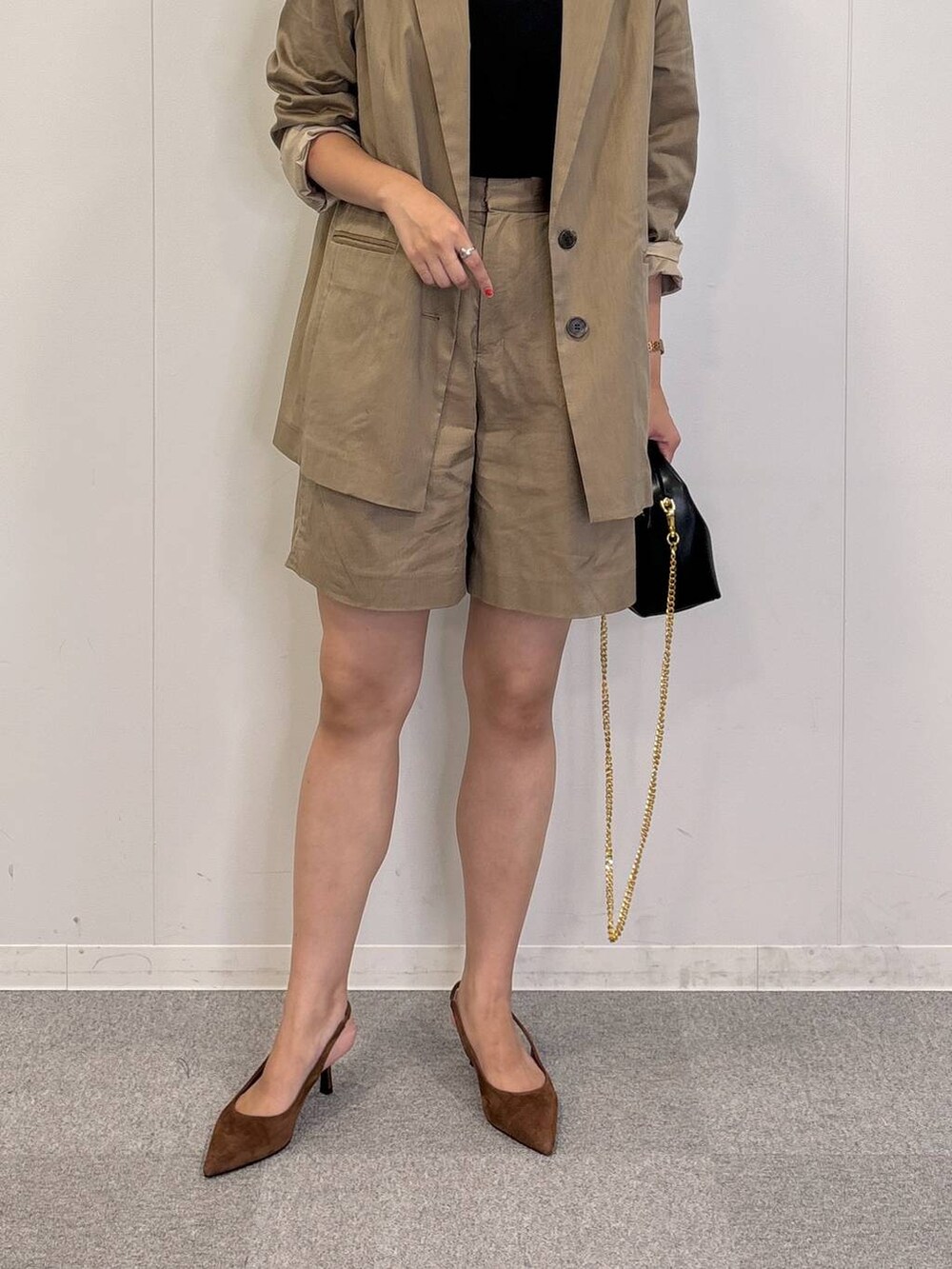 ブラック系のショルダーバッグ、ブラック系のTシャツ/カットソー、ベージュ系のテーラードジャケットを着用したレディースの秋コーディネートの4枚目の写真