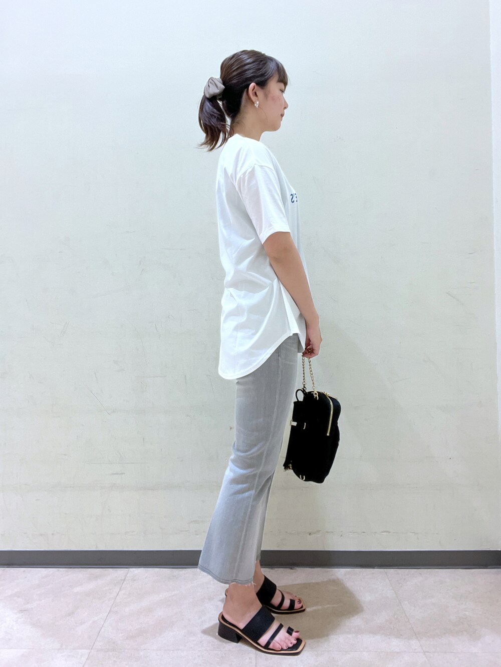 ブルー系のTシャツ/カットソー、ブラック系のボディバッグ/ウエストポーチ、イエロー系のサンダルを着用したレディースの夏コーディネートの3枚目の写真