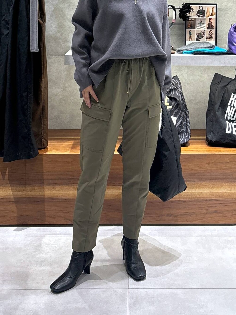 グリーン系のカーゴパンツ、ブラック系のトートバッグ、グレー系のニット/セーターを着用したレディースの冬コーディネートの4枚目の写真