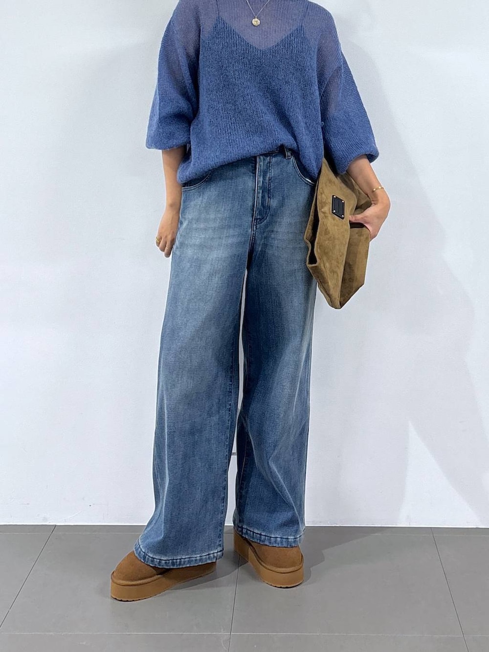 ブルー系のデニムパンツ、イエロー系のブーツ、イエロー系のトートバッグを着用したレディースの秋コーディネートの4枚目の写真