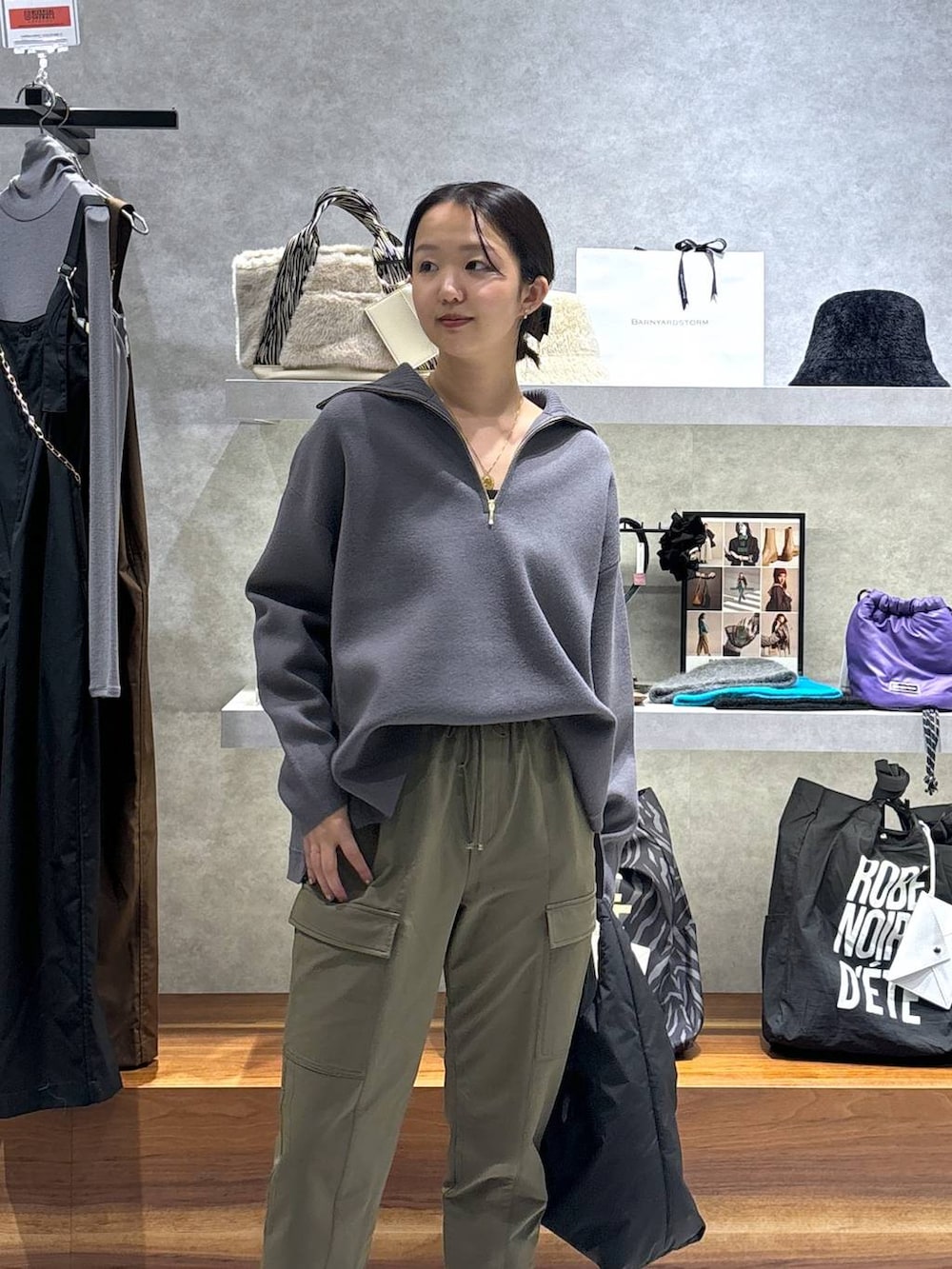 グリーン系のカーゴパンツ、ブラック系のトートバッグ、グレー系のニット/セーターを着用したレディースの冬コーディネートの2枚目の写真