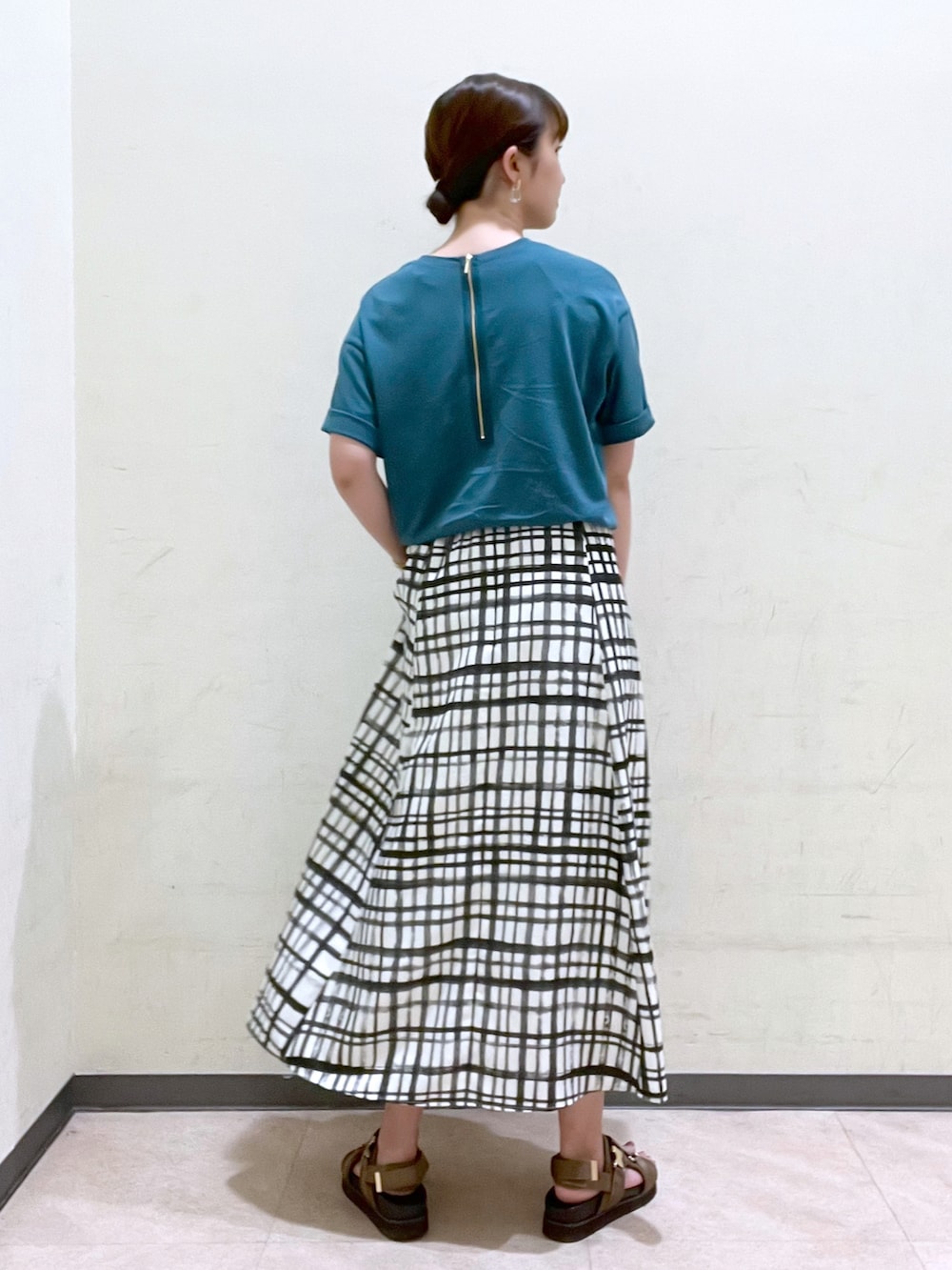 グリーン系のTシャツ/カットソー、ホワイト系のスカート、ブラウン系のボディバッグ/ウエストポーチを着用したレディースの夏コーディネートの2枚目の写真