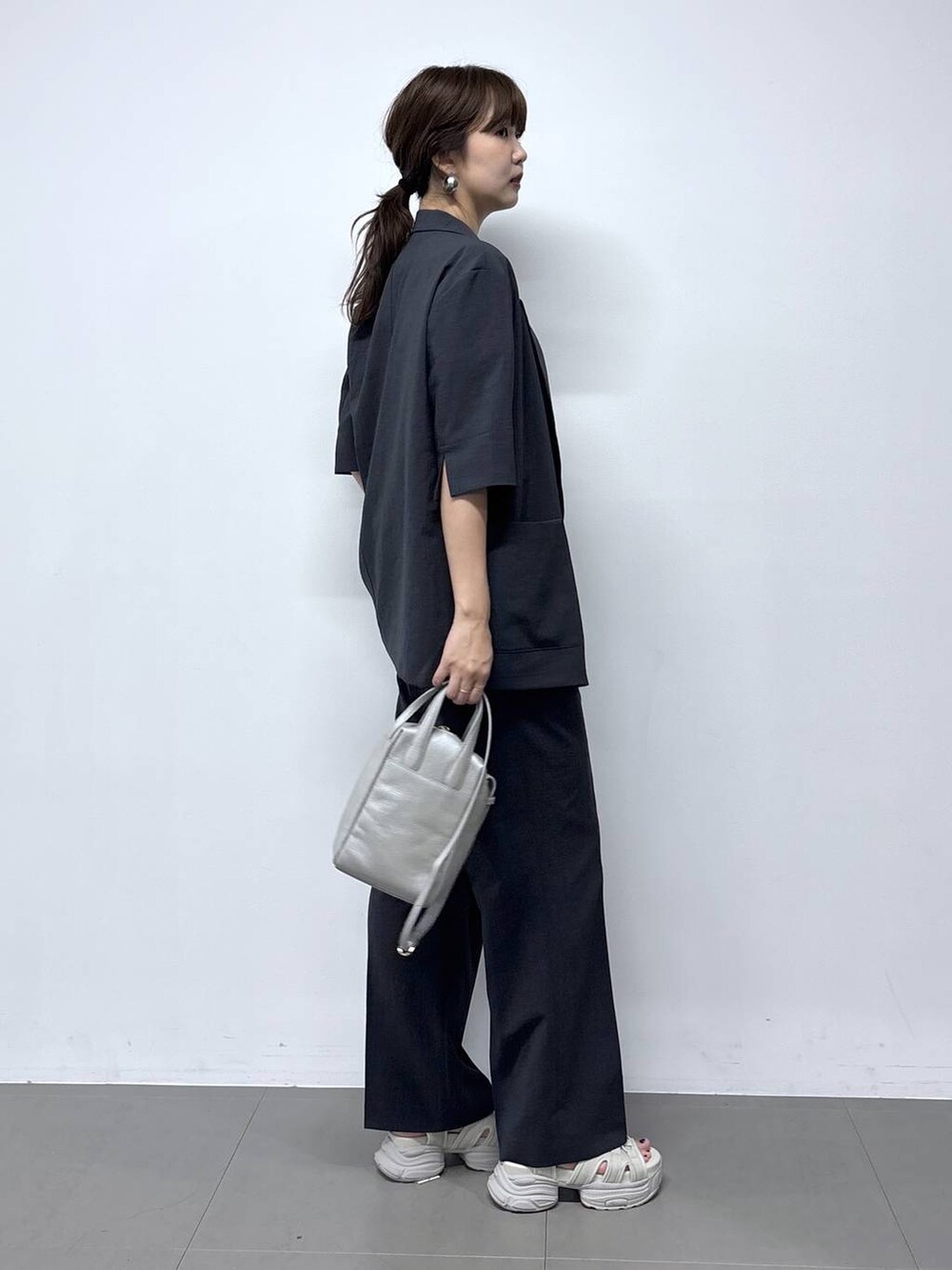シルバー系のショルダーバッグ、グレー系のサンダル、ブルー系のTシャツ/カットソーを着用したレディースの春コーディネートの3枚目の写真