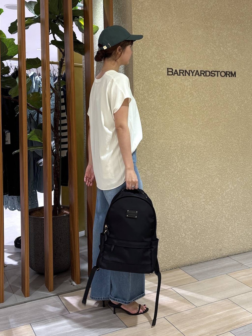 ブルー系のデニムパンツ、ブラック系のバックパック/リュック、ホワイト系のシャツ/ブラウスを着用したレディースの春コーディネートの5枚目の写真