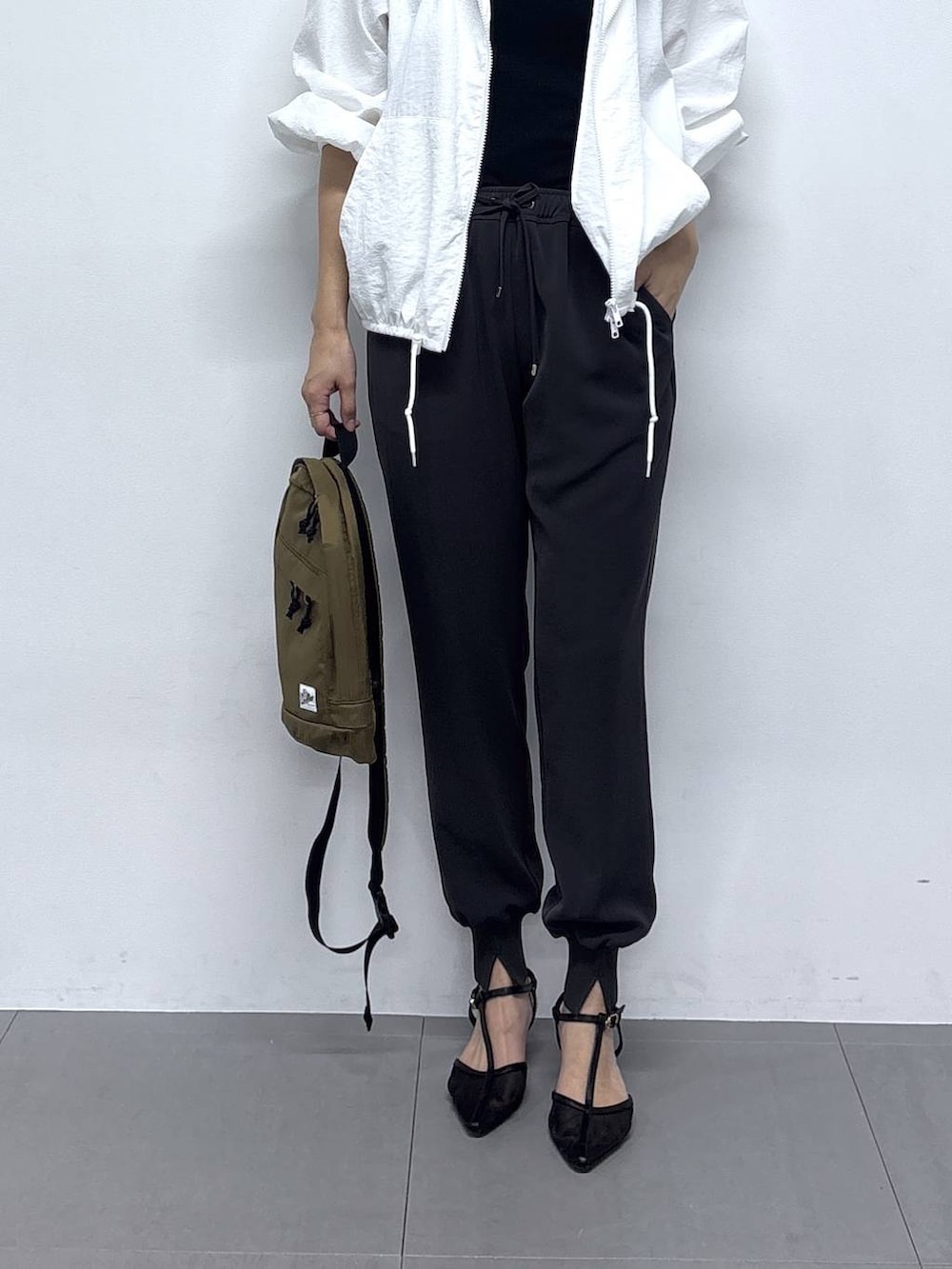 ホワイト系のブルゾン、ブラック系のパンプス、グレー系のその他パンツを着用したレディースの春コーディネートの4枚目の写真