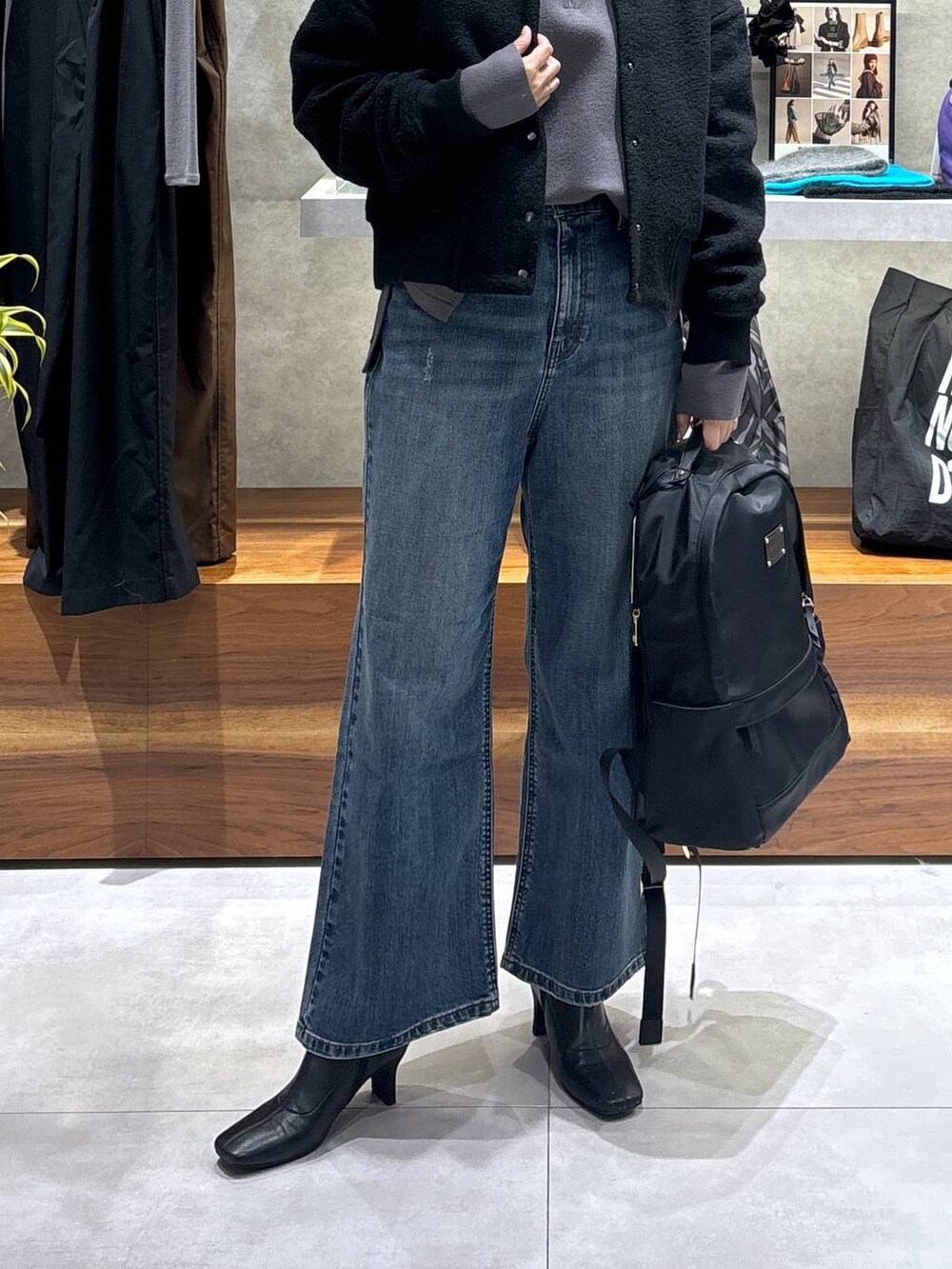 ブラック系のバックパック/リュック、ブラック系のブルゾン、ブルー系のデニムパンツを着用したレディースの冬コーディネートの6枚目の写真