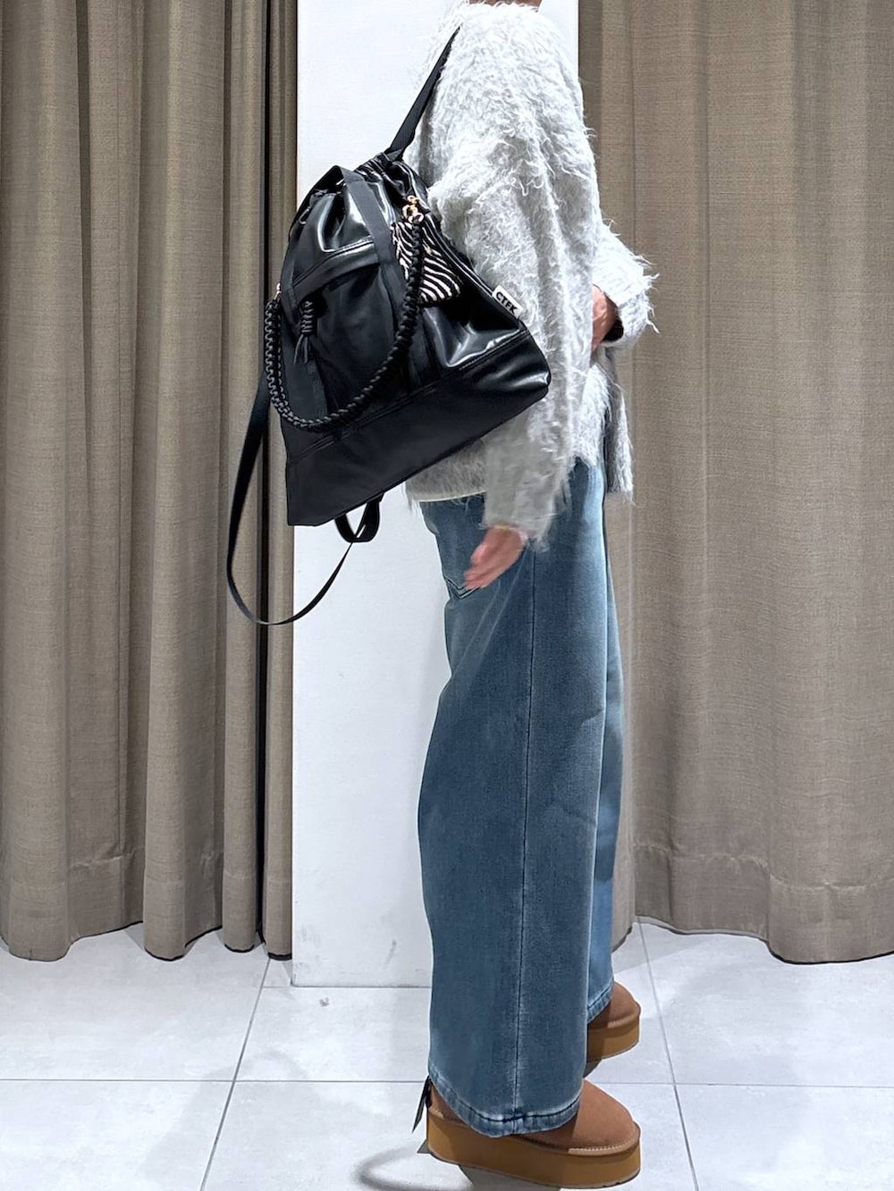 ブラック系のバックパック/リュック、ブルー系のデニムパンツ、イエロー系のブーツを着用したレディースの秋コーディネートの4枚目の写真