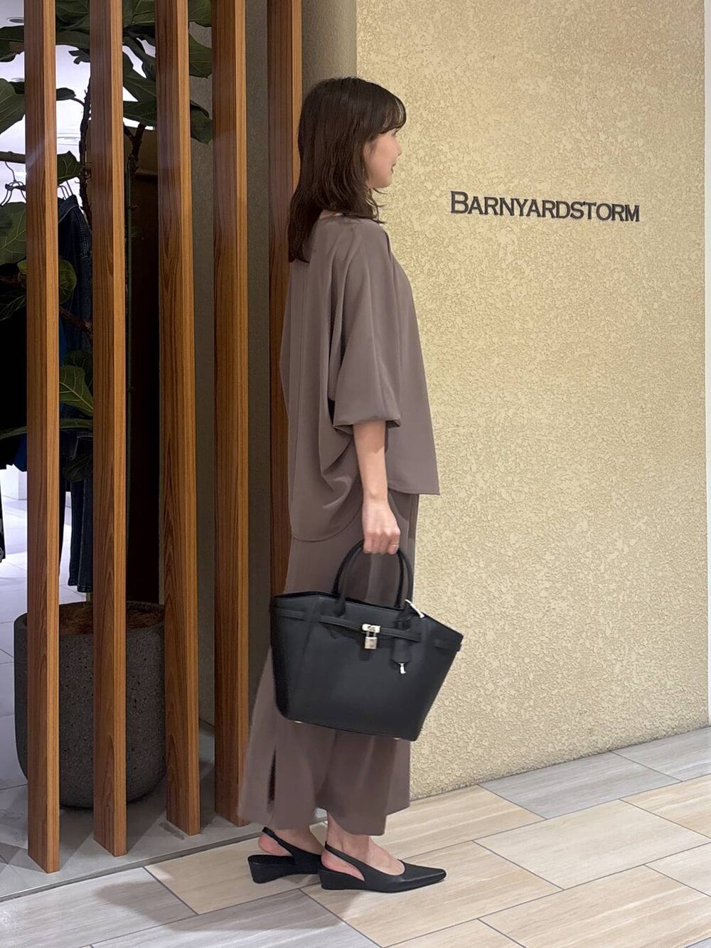 グリーン系のスカート、グリーン系のTシャツ/カットソー、ブラック系のハンドバッグを着用したレディースの冬コーディネートの6枚目の写真