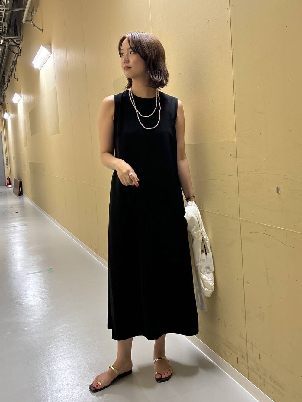 ホワイト系のパーカー、ブラック系のワンピースを着用したレディースの夏コーディネートの3枚目の写真