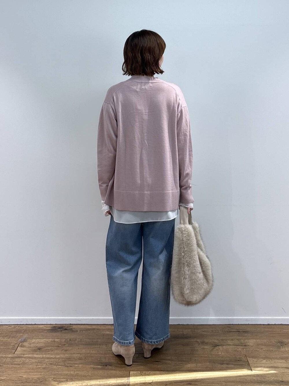 ベージュ系のショルダーバッグ、ブルー系のデニムパンツ、ホワイト系のTシャツ/カットソーを着用したレディースの秋コーディネートの4枚目の写真