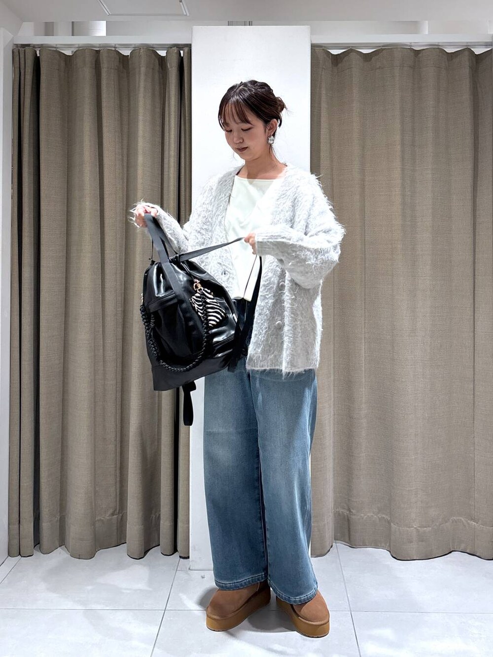 ブラック系のバックパック/リュック、ブルー系のデニムパンツ、イエロー系のブーツを着用したレディースの秋コーディネートの5枚目の写真