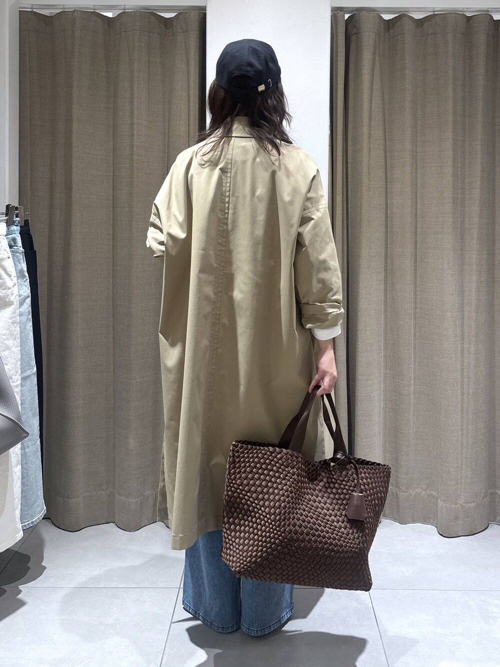 ホワイト系のTシャツ/カットソー、ブルー系のデニムパンツ、ベージュ系のステンカラーコートを着用したレディースの冬コーディネートの5枚目の写真