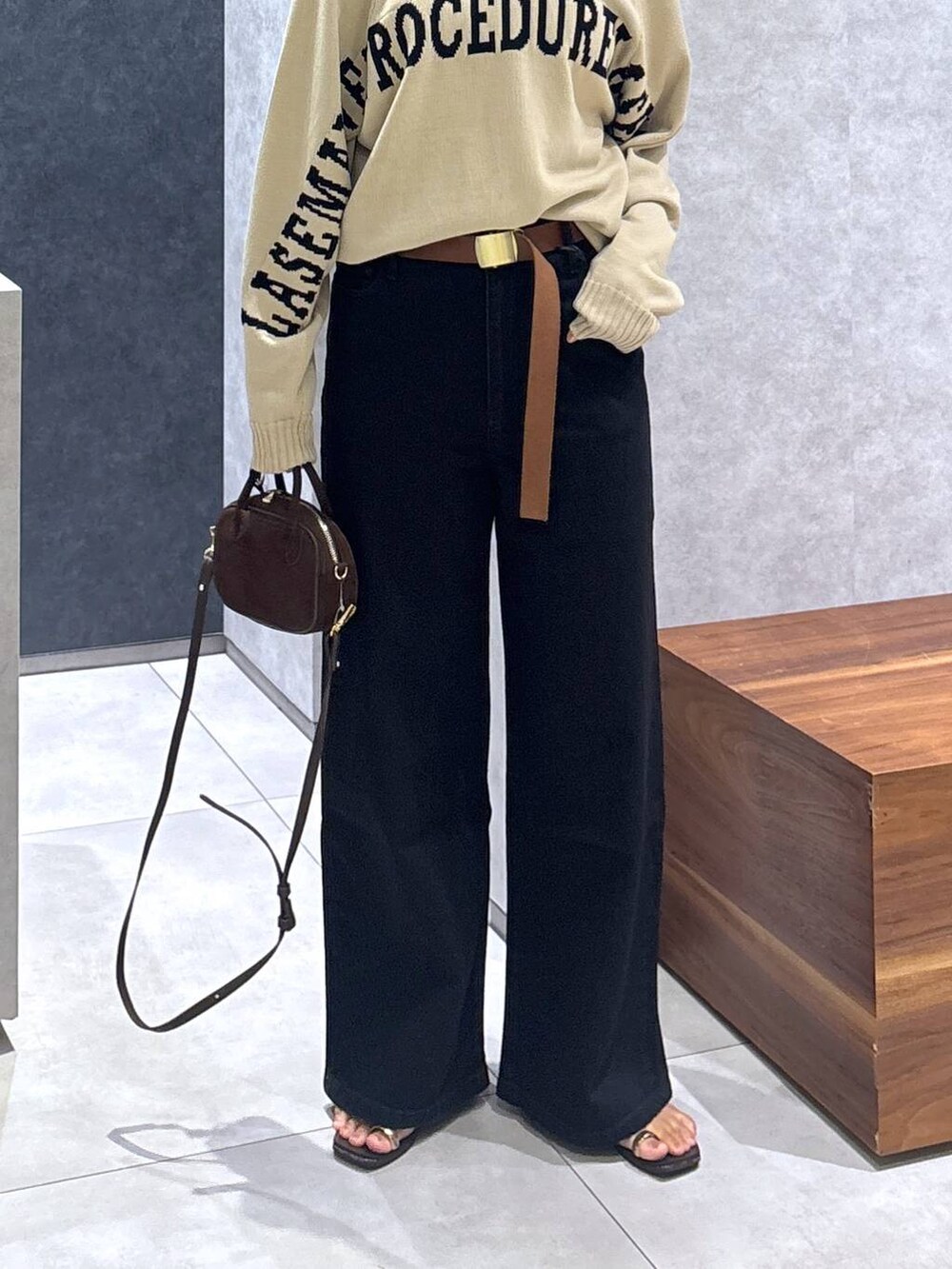 ブラック系のデニムパンツ、ベージュ系のカーディガン/ボレロ、ブラウン系のショルダーバッグを着用したレディースの夏コーディネートの6枚目の写真