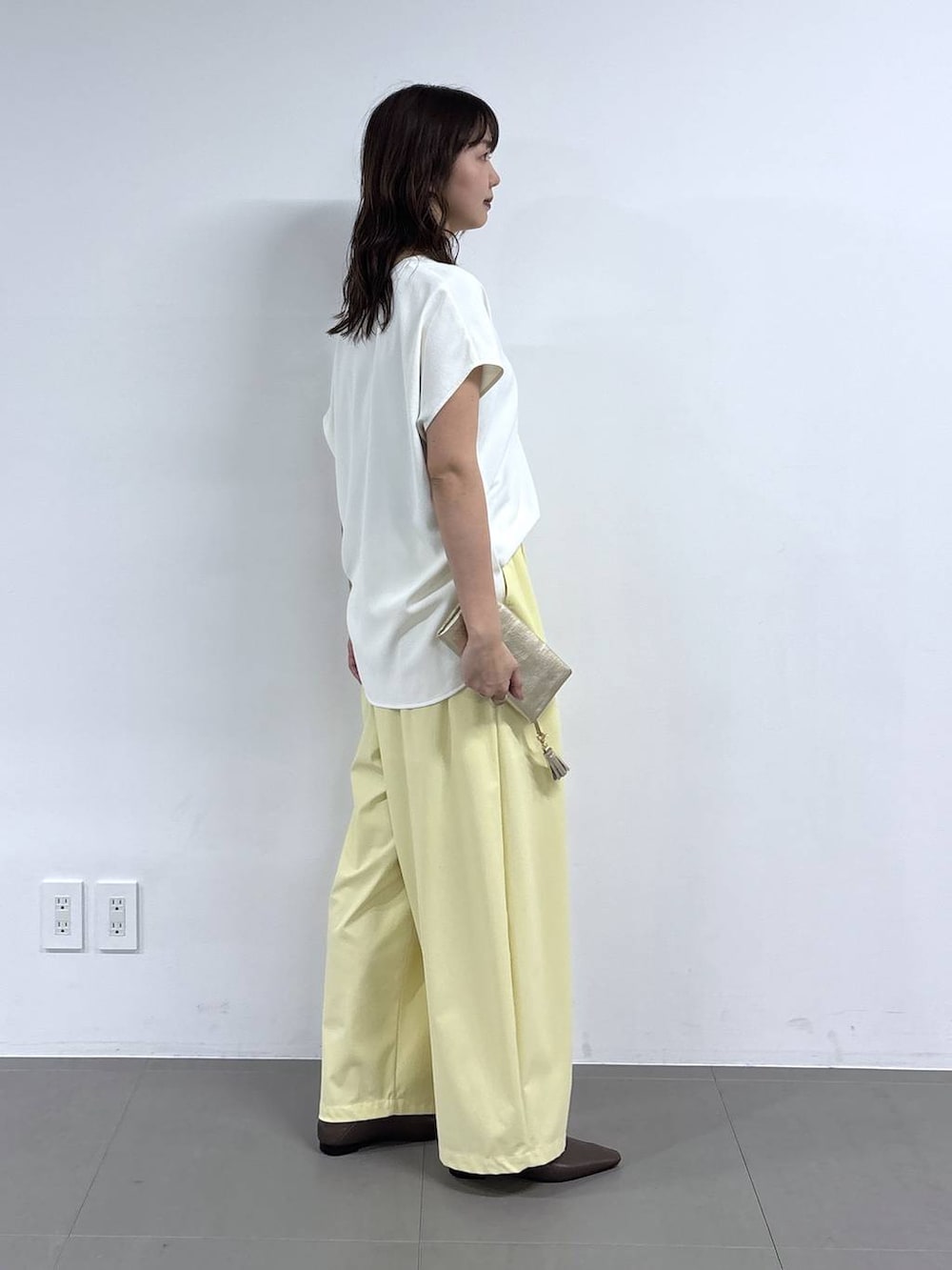ホワイト系のシャツ/ブラウス、イエロー系のその他パンツ、ブラウン系のパンプスを着用したレディースの春コーディネートの6枚目の写真
