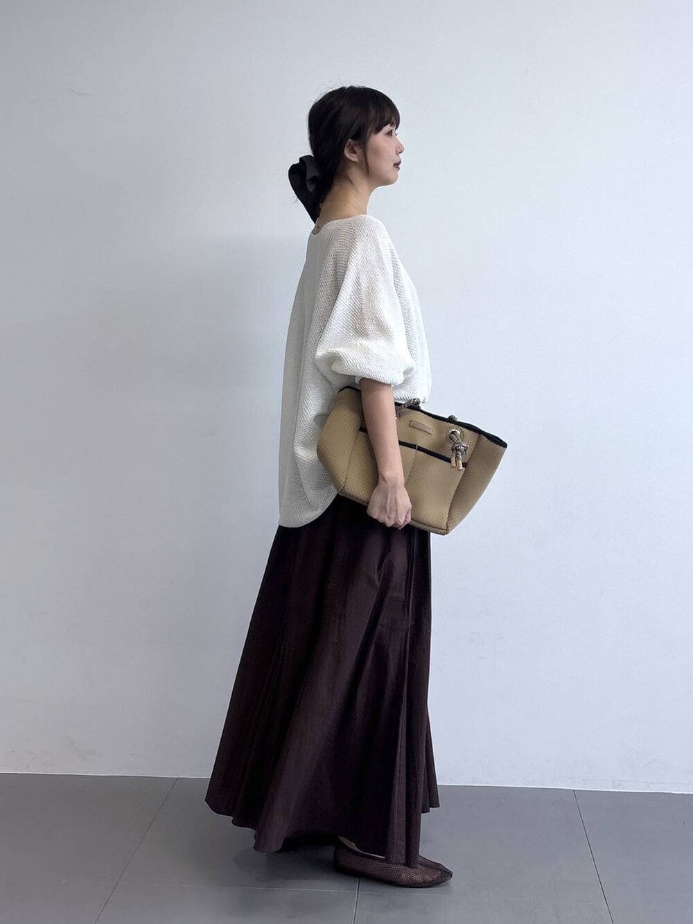 ブラウン系のトートバッグを着用したレディースの冬コーディネートの3枚目の写真