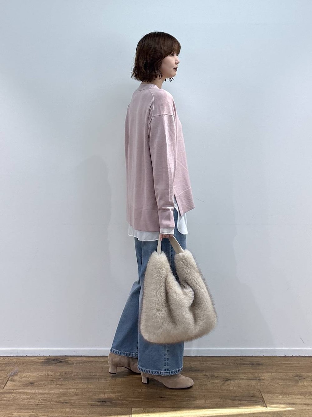 ベージュ系のショルダーバッグ、ブルー系のデニムパンツ、ホワイト系のTシャツ/カットソーを着用したレディースの秋コーディネートの5枚目の写真