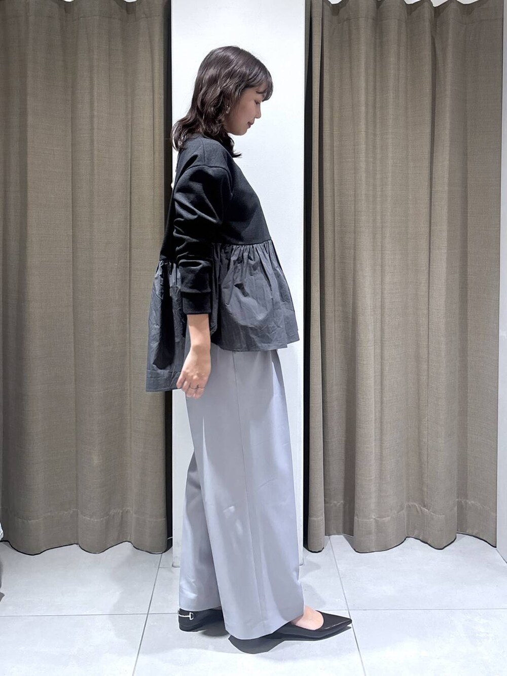 グレー系のその他パンツ、ブラック系のハンドバッグ、グレー系のTシャツ/カットソーを着用したレディースの冬コーディネートの2枚目の写真