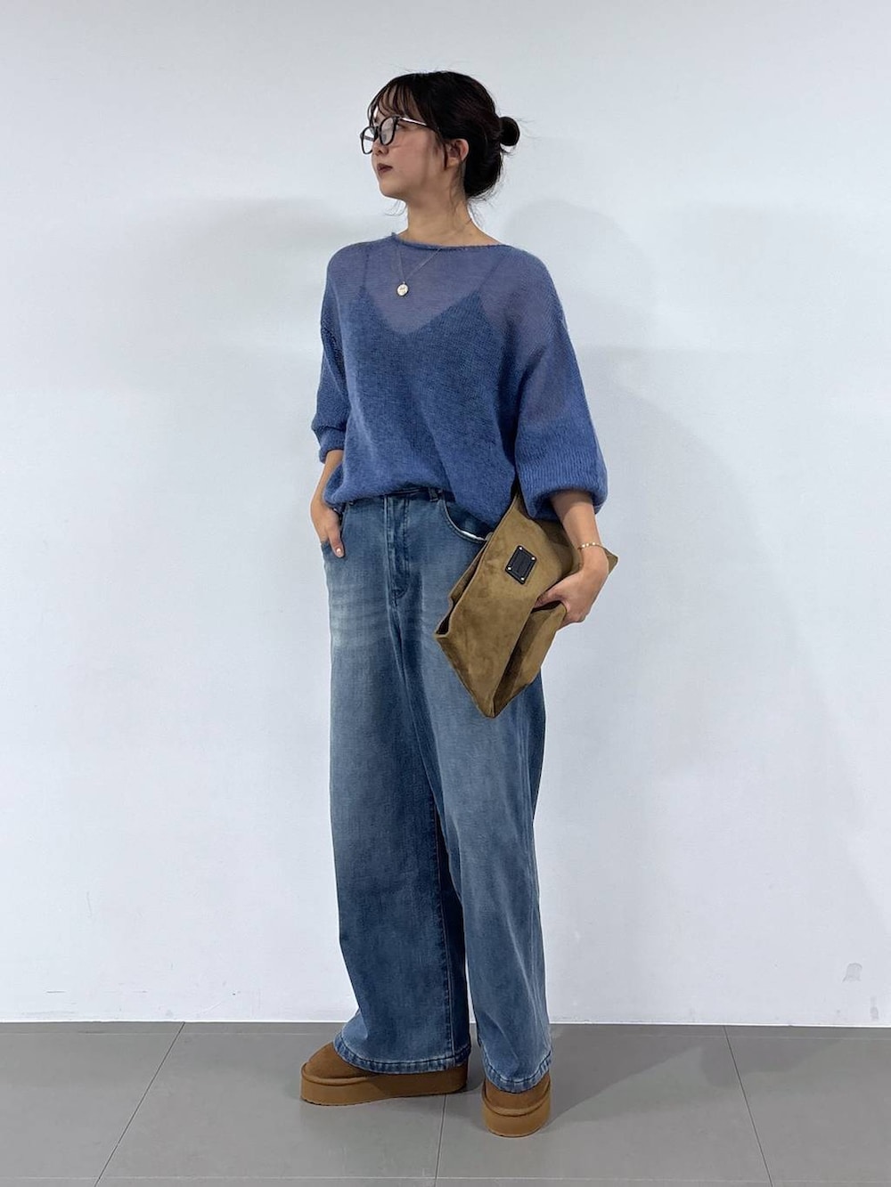 ブルー系のデニムパンツ、イエロー系のブーツ、イエロー系のトートバッグを着用したレディースの秋コーディネートの6枚目の写真