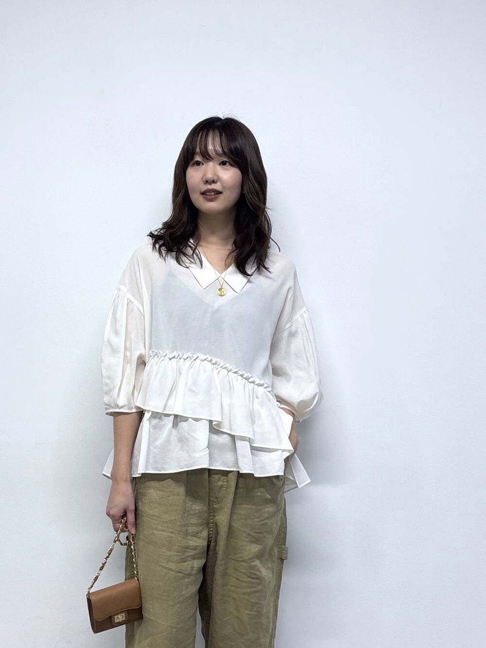 ベージュ系のその他パンツ、ベージュ系のパンプス、ベージュ系のショルダーバッグを着用したレディースの春コーディネートの3枚目の写真