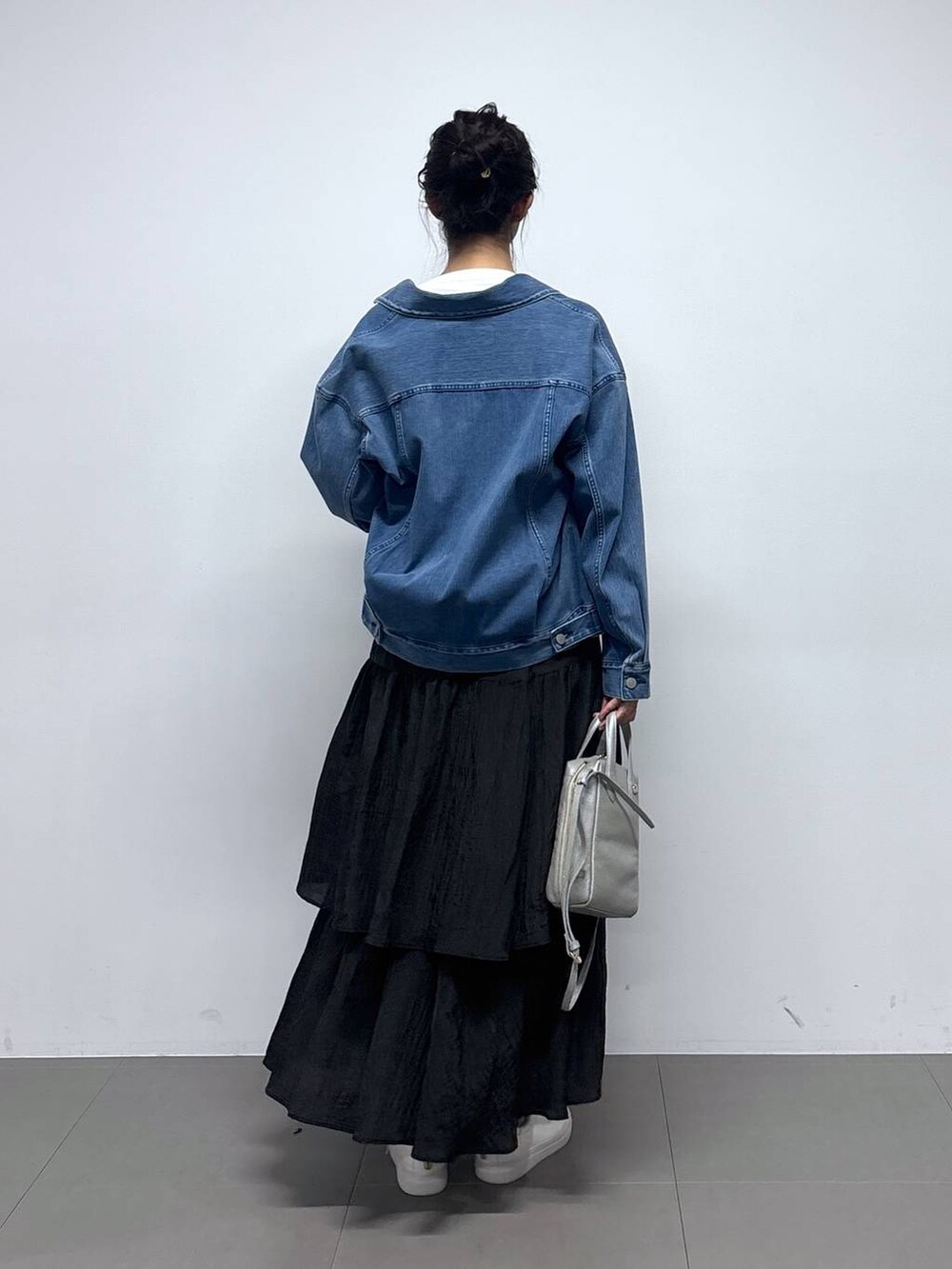 ブルー系のデニムジャケット、ホワイト系のTシャツ/カットソー、ブラック系のスカートを着用したレディースの冬コーディネートの5枚目の写真