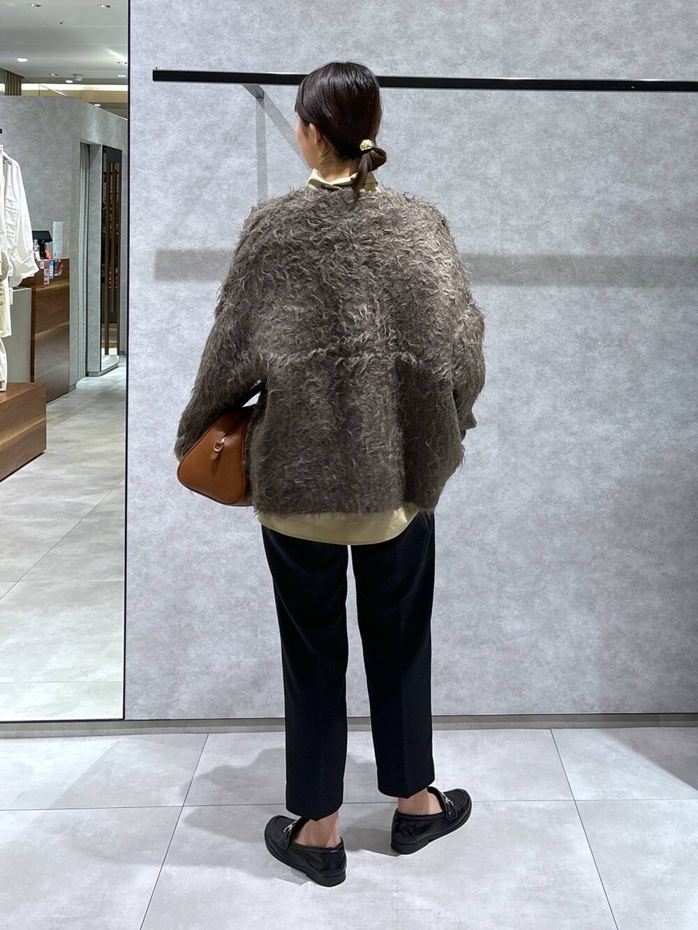 ブラウン系のカーディガン/ボレロ、イエロー系のボストンバッグ、ブラック系のその他パンツを着用したレディースの冬コーディネートの5枚目の写真
