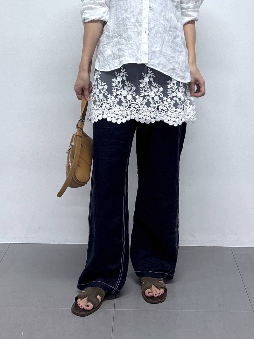 ホワイト系のシャツ/ブラウス、ブルー系のその他パンツ、ブラウン系のショルダーバッグを着用したレディースの春コーディネートの6枚目の写真