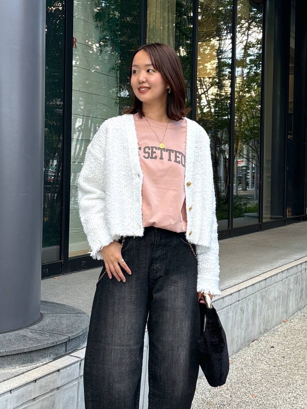 ブラック系のデニムパンツ、ブラック系のブーツ、ブラック系のトートバッグを着用したレディースの秋コーディネートの5枚目の写真