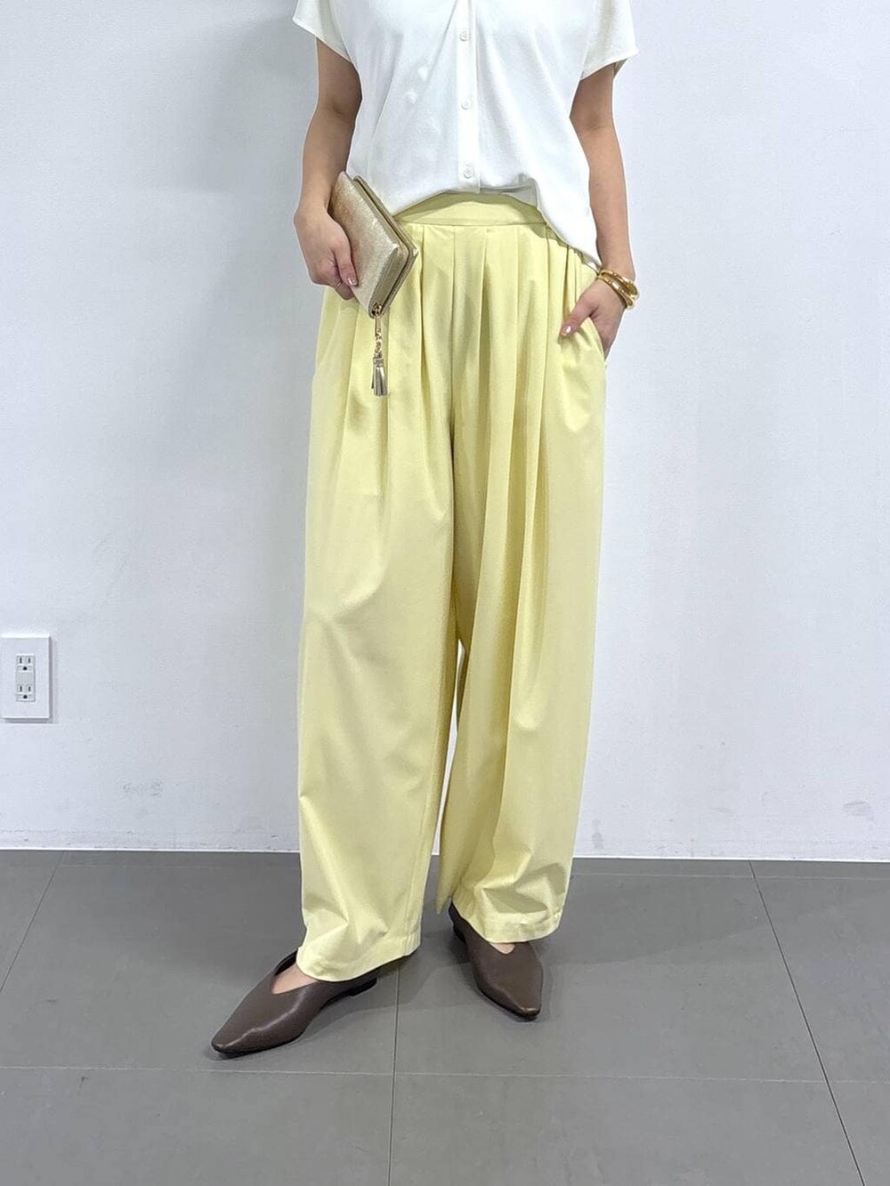 ホワイト系のシャツ/ブラウス、イエロー系のその他パンツ、ブラウン系のパンプスを着用したレディースの春コーディネートの4枚目の写真