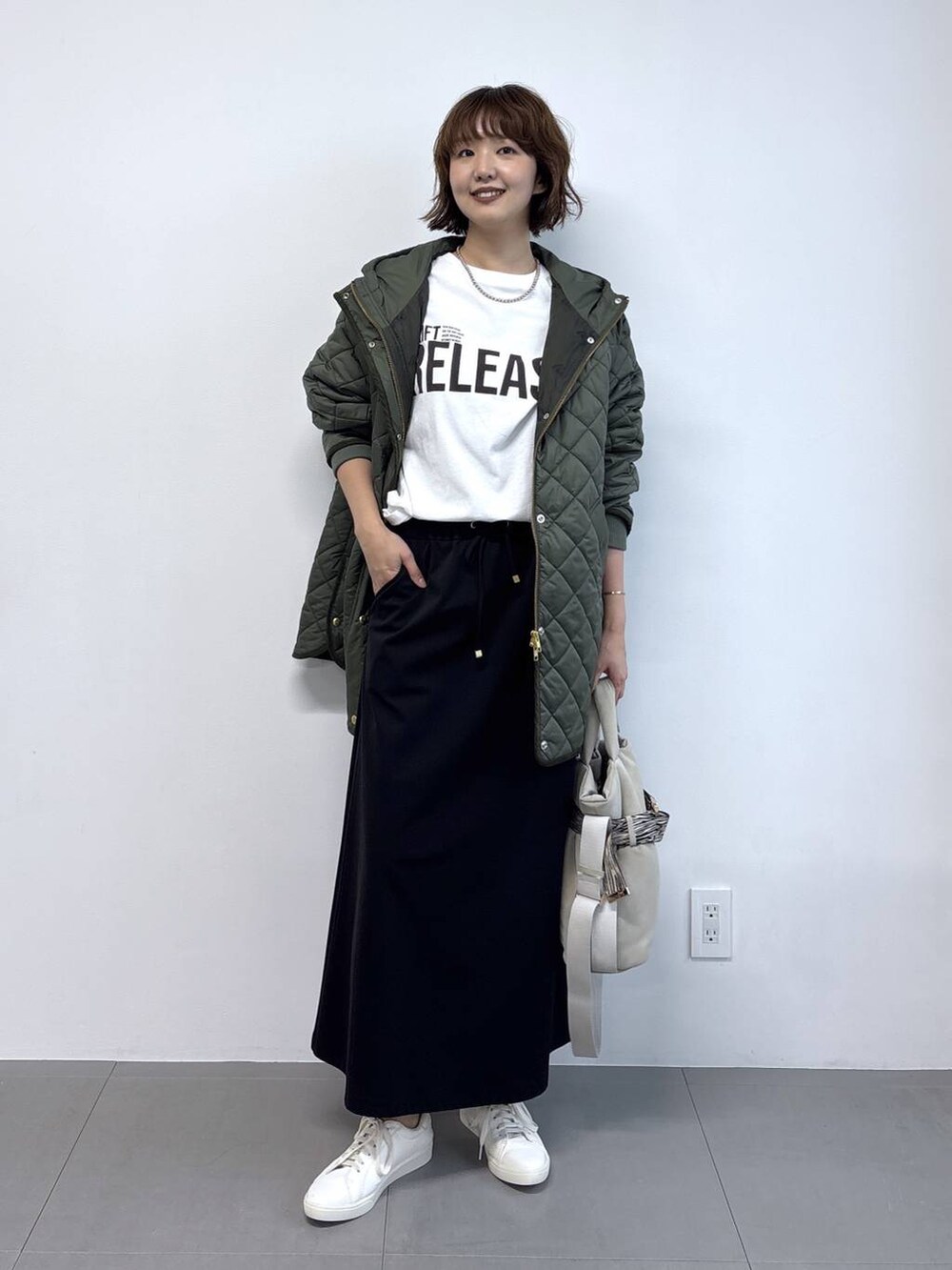 ホワイト系のTシャツ/カットソー、グレー系のトートバッグ、ブラック系のスカートを着用したレディースの秋コーディネートの6枚目の写真