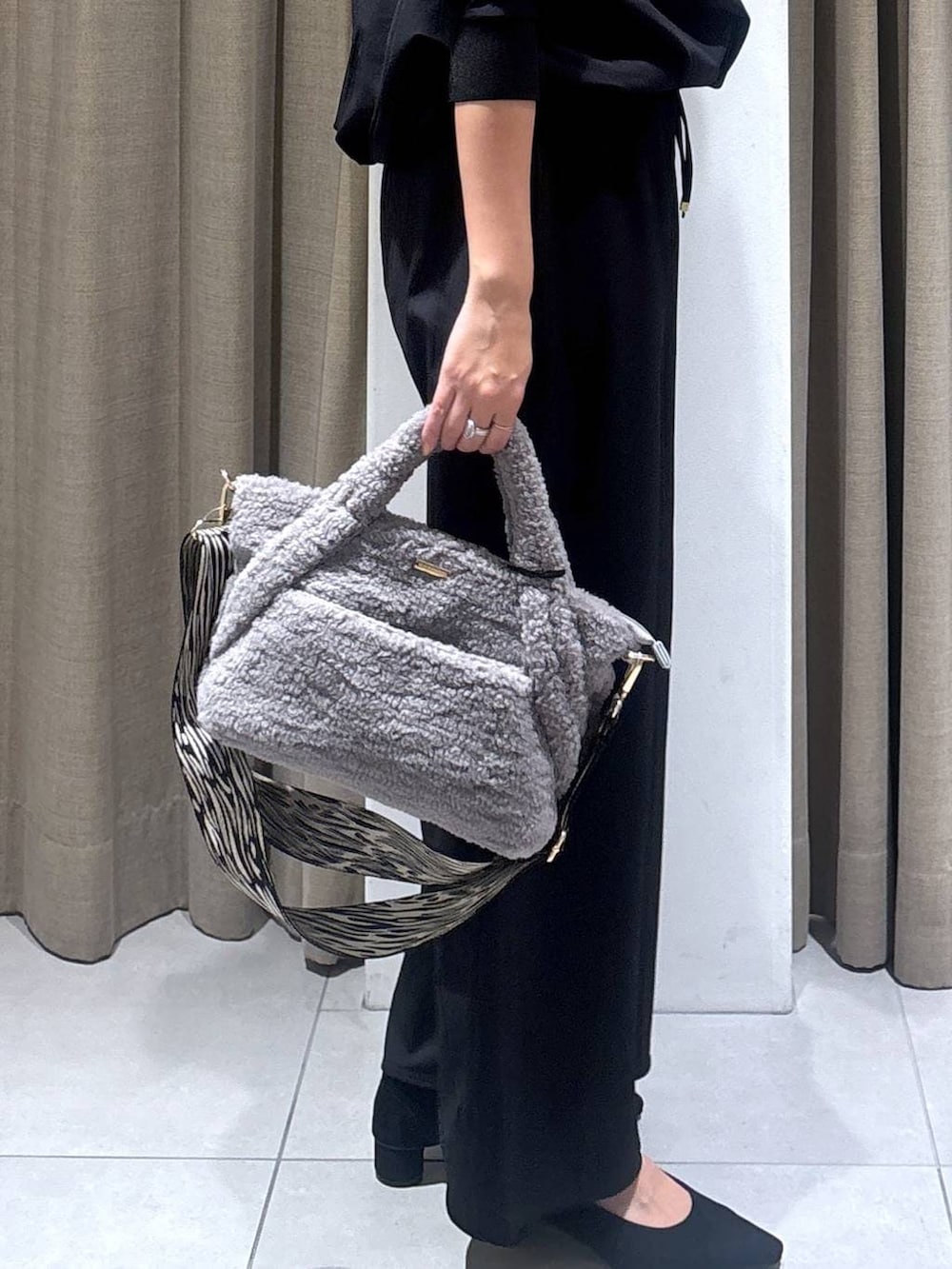 ブラック系のパンプス、グレー系のトートバッグ、ブラック系のTシャツ/カットソーを着用したレディースの秋コーディネートの6枚目の写真