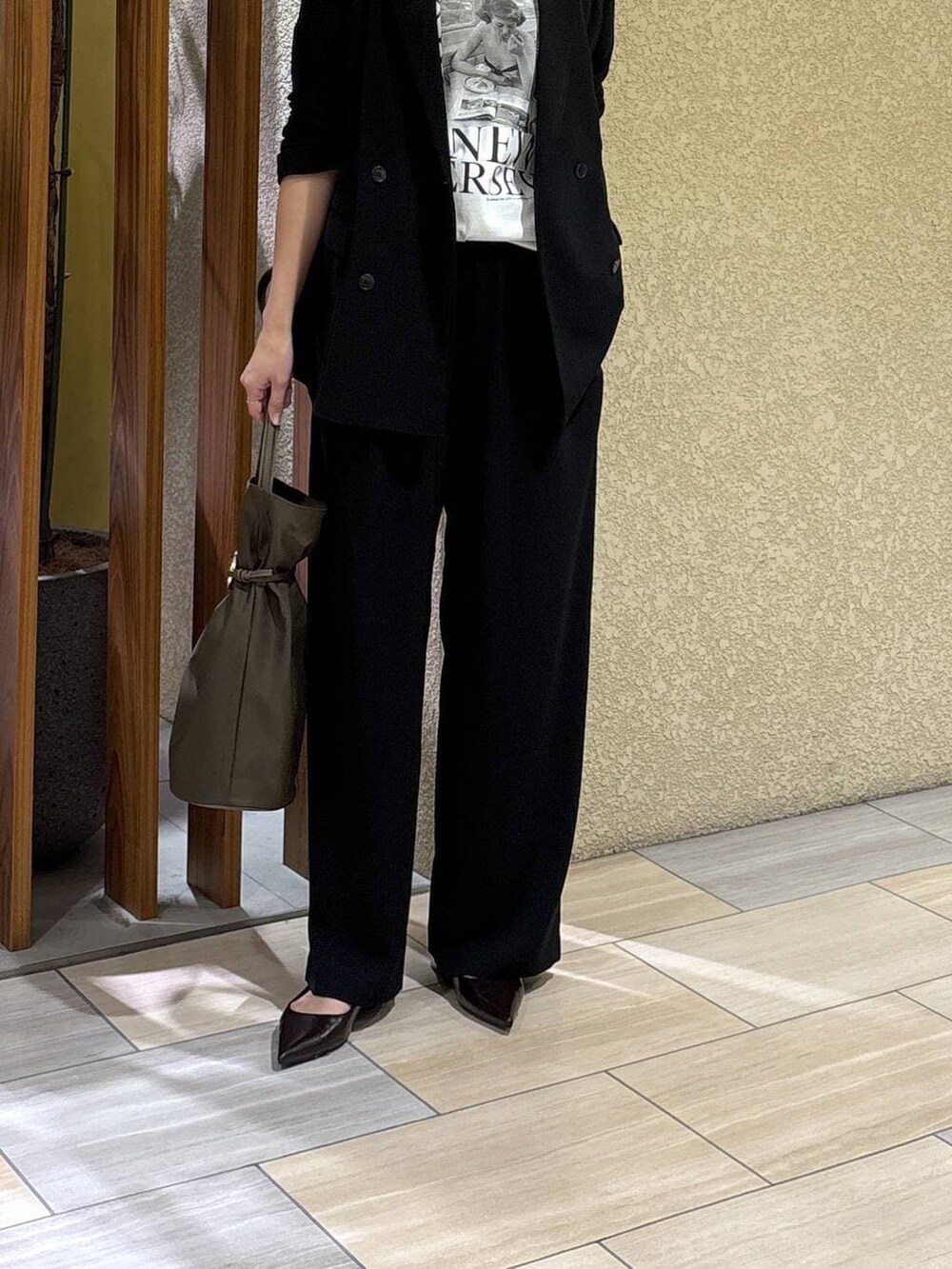 ブラック系のスラックス、ブラック系のテーラードジャケット、ホワイト系のTシャツ/カットソーを着用したレディースの冬コーディネートの4枚目の写真