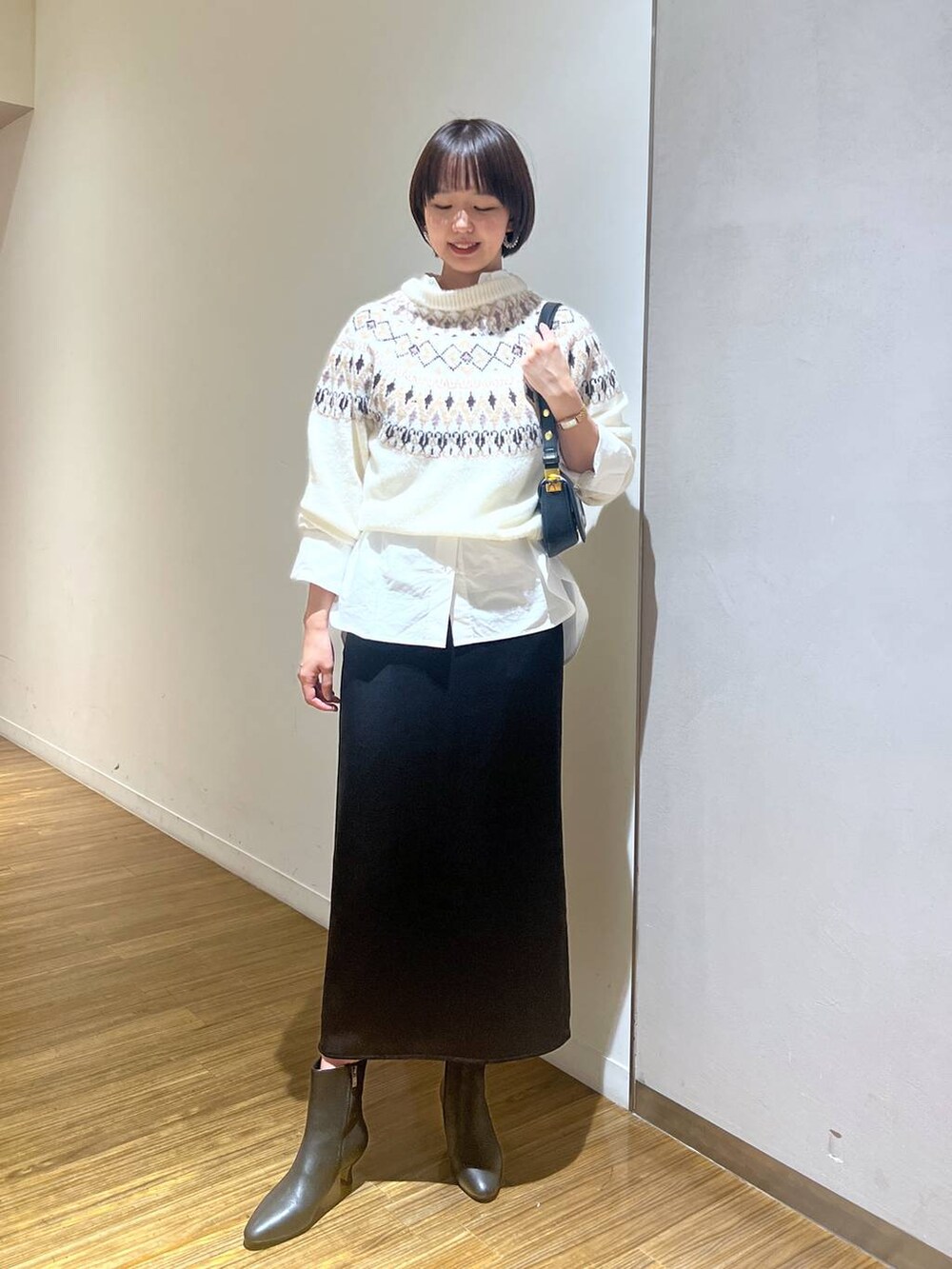 ブラック系のブーツ、ブラック系のショルダーバッグ、ホワイト系のシャツ/ブラウスを着用したレディースの秋コーディネートの6枚目の写真