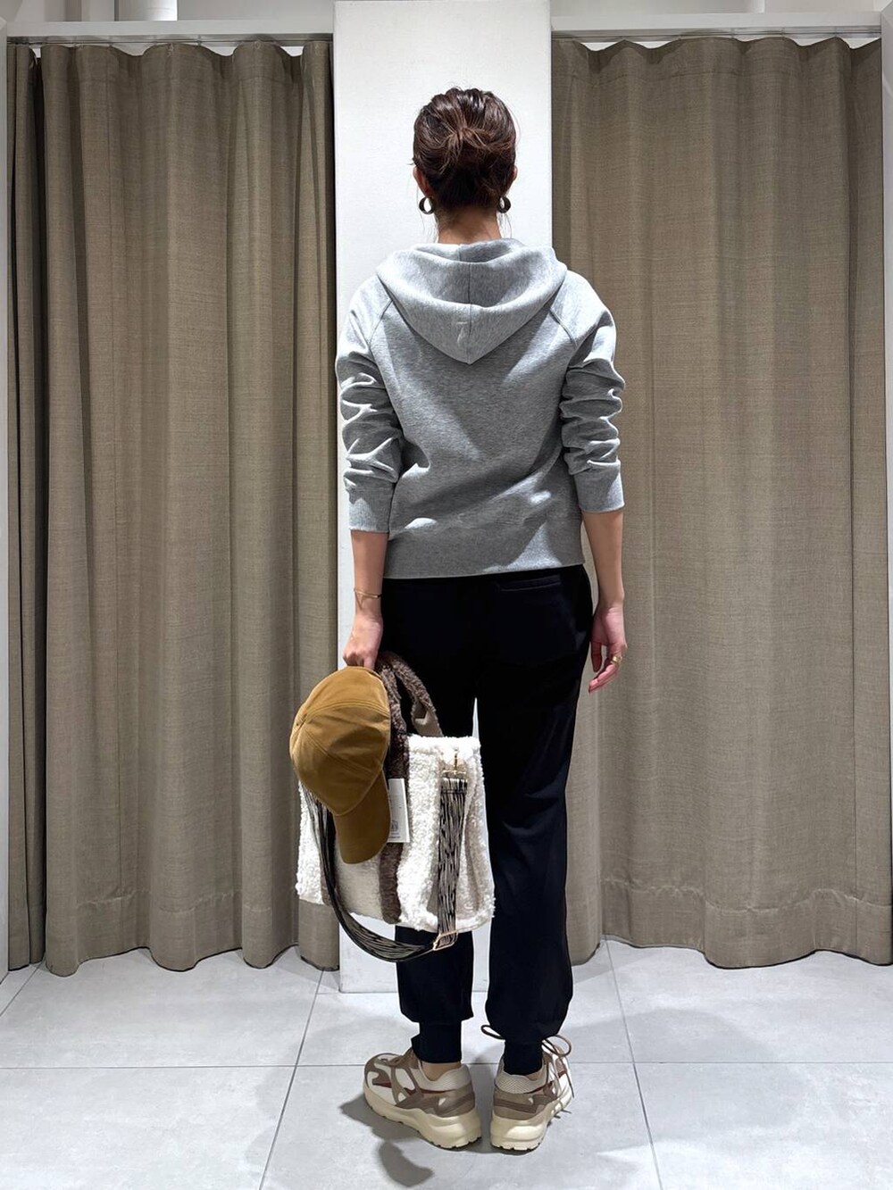 ホワイト系のトートバッグ、ブラック系のその他パンツ、ブラウン系のスニーカーを着用したレディースの秋コーディネートの5枚目の写真