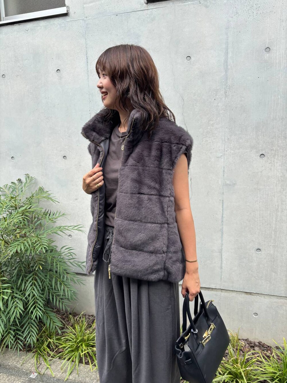 ブラック系のショルダーバッグ、グレー系のその他パンツ、グレー系のベストを着用したレディースの夏コーディネートの4枚目の写真