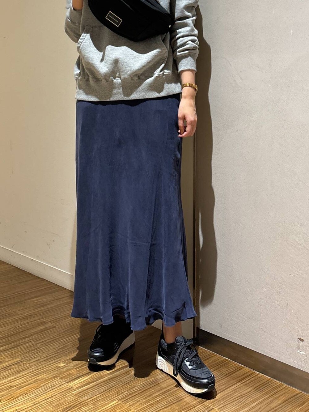 ブラック系のボディバッグ/ウエストポーチ、グレー系のパーカー、ブラック系のスニーカーを着用したレディースの冬コーディネートの3枚目の写真