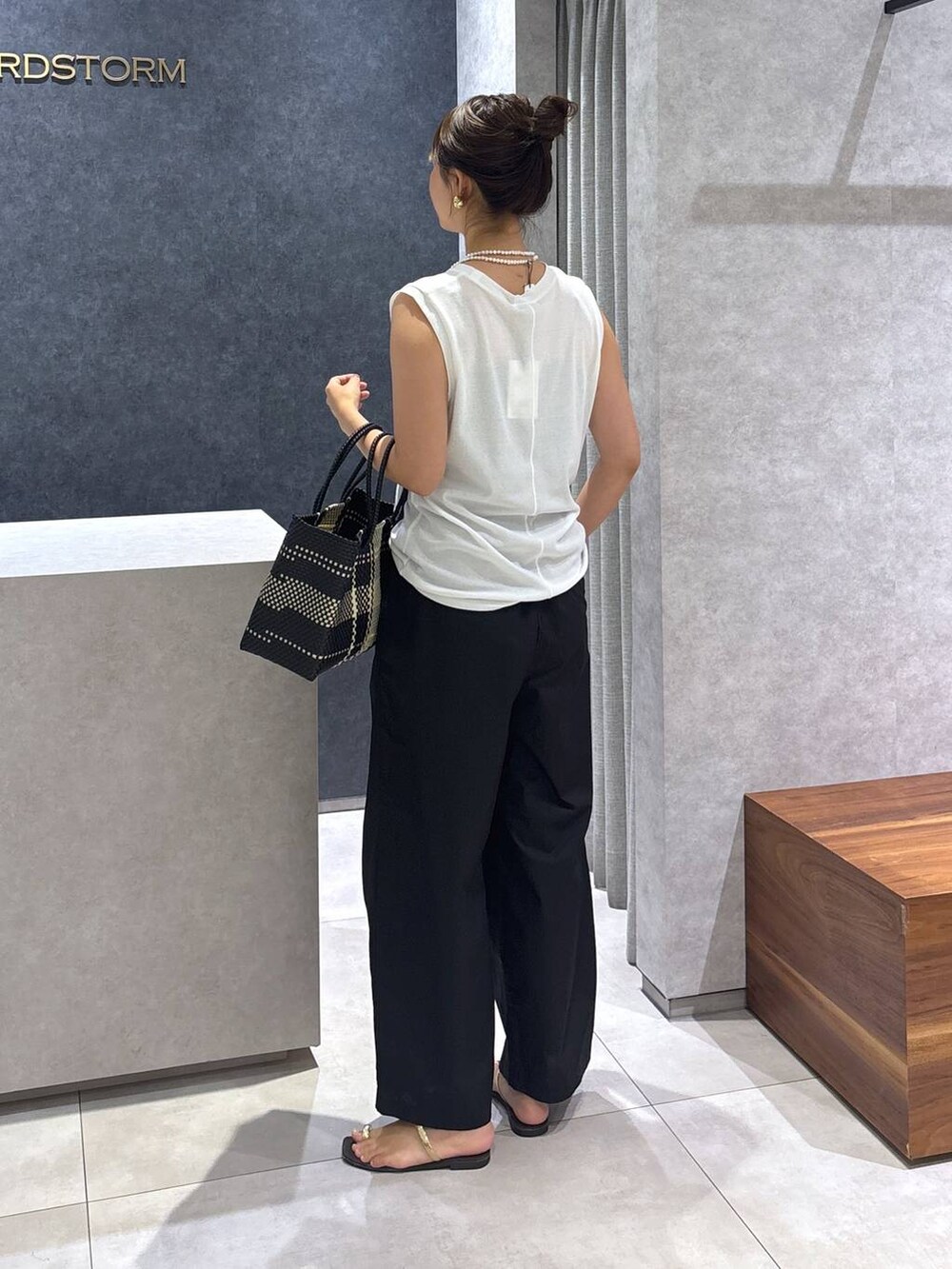 ブラック系のその他パンツ、その他のトートバッグ、ホワイト系のTシャツ/カットソーを着用したレディースの夏コーディネートの4枚目の写真