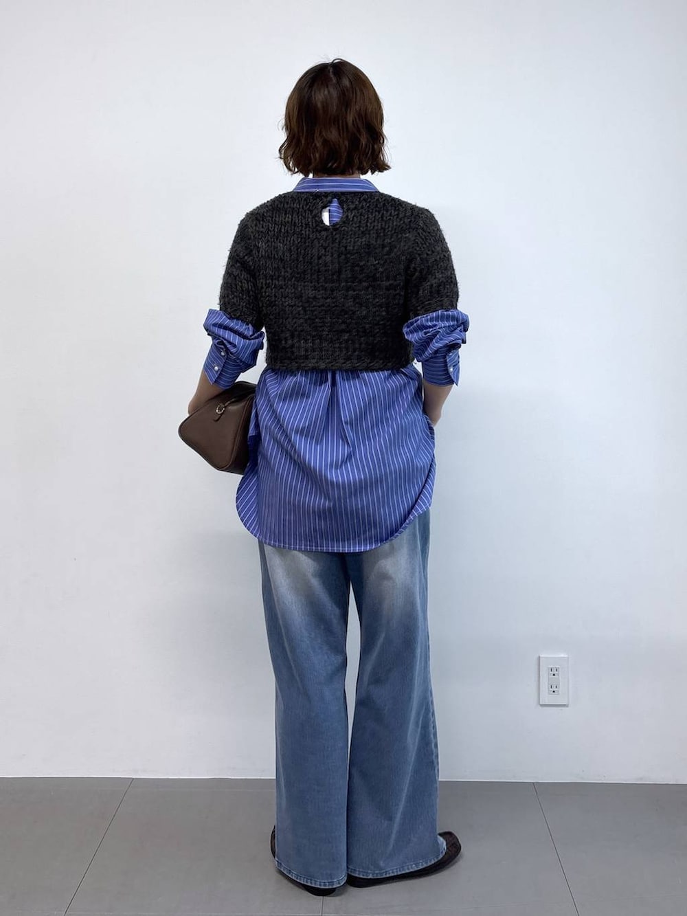 ブルー系のシャツ/ブラウス、ブラウン系のボストンバッグ、ブルー系のデニムパンツを着用したレディースの秋コーディネートの4枚目の写真