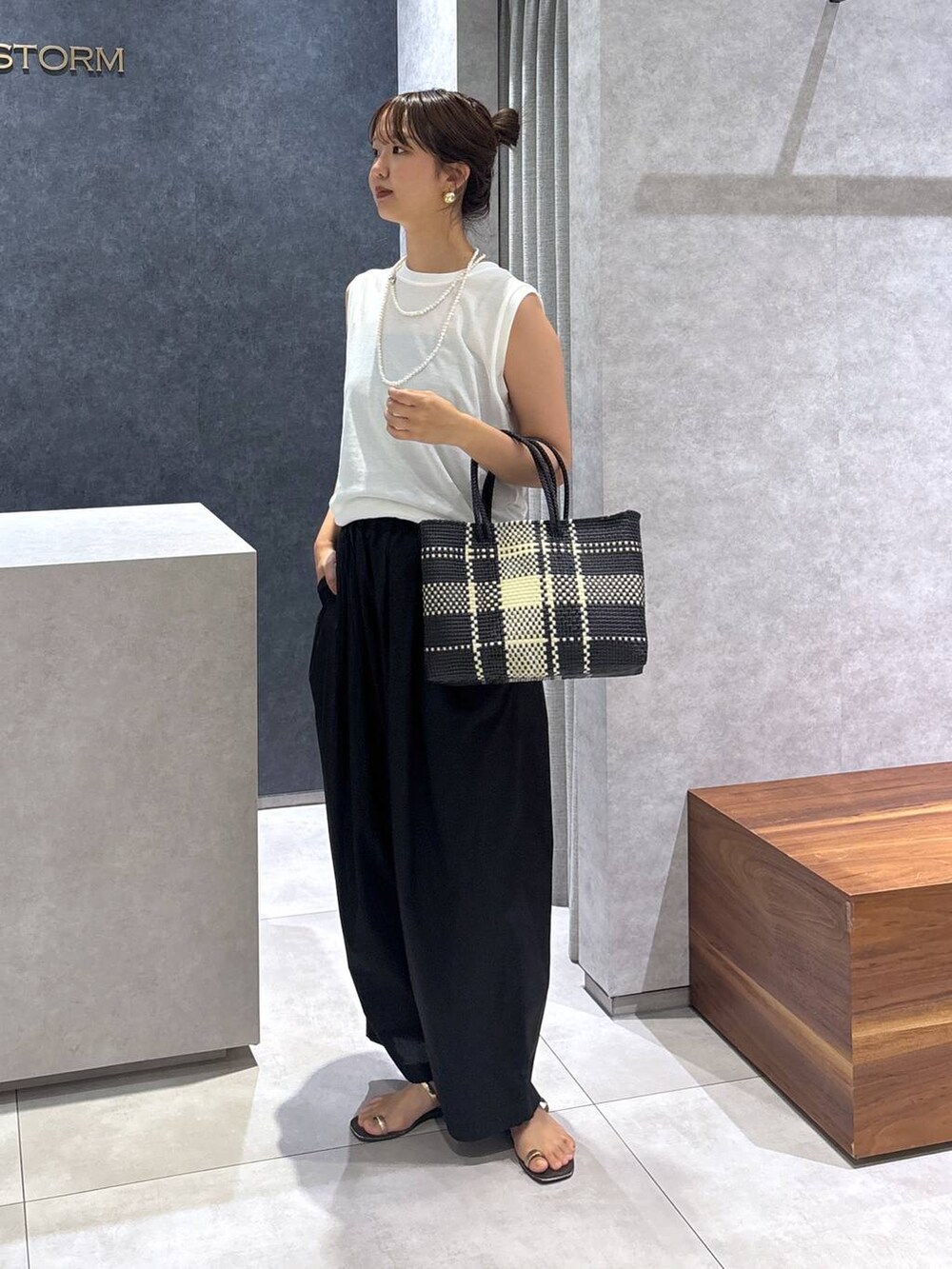 ブラック系のその他パンツ、その他のトートバッグ、ホワイト系のTシャツ/カットソーを着用したレディースの夏コーディネートの3枚目の写真