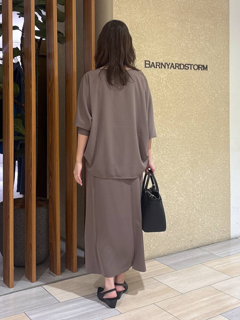 グリーン系のスカート、グリーン系のTシャツ/カットソー、ブラック系のハンドバッグを着用したレディースの冬コーディネートの5枚目の写真