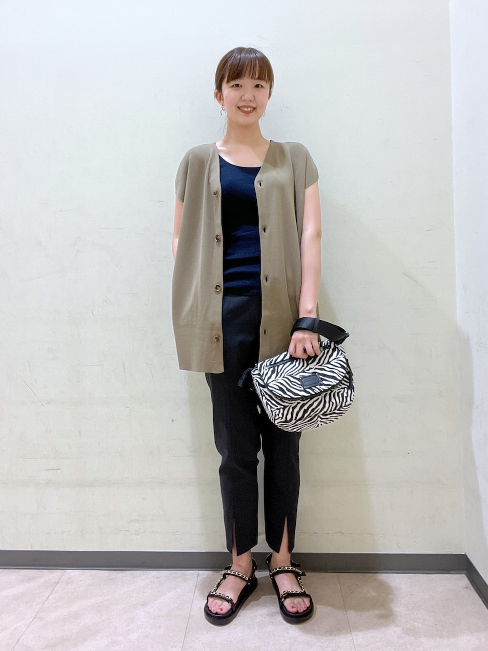 グリーン系のベスト、ブラック系のその他パンツ、ブラック系のシューズを着用したレディースの夏コーディネートの4枚目の写真